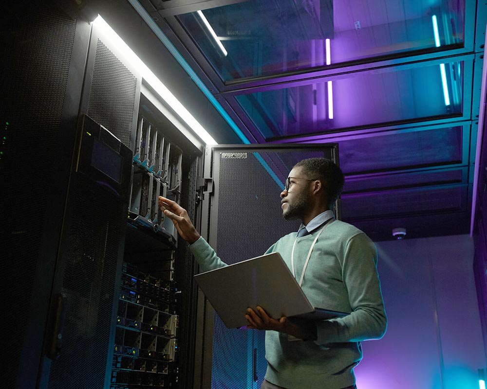 Man with laptop at data center