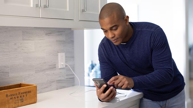 Man holding smartphone, controlling home