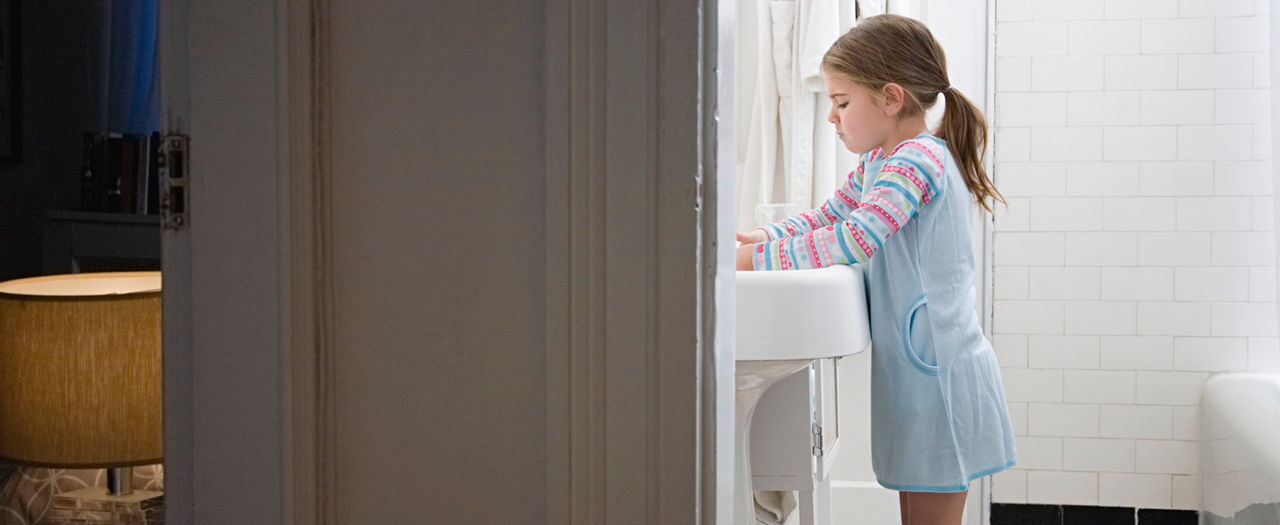 Little girl washing hands in bathroom